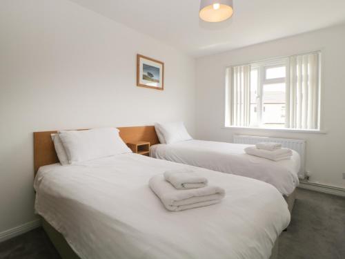 Dos camas en una habitación con toallas. en Harcombe House Bungalow 4, en Newton Abbot