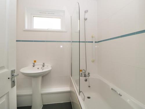 a white bathroom with a sink and a shower at Harcombe House&nbspPet Free Bungalow in Newton Abbot