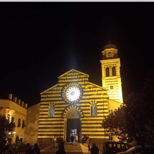 a building with a clock on the front of it at night at La Terrazza sul Mare in Levanto