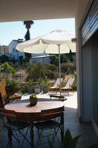 an umbrella and a table and chairs on a patio at I due carrubi in Custonaci