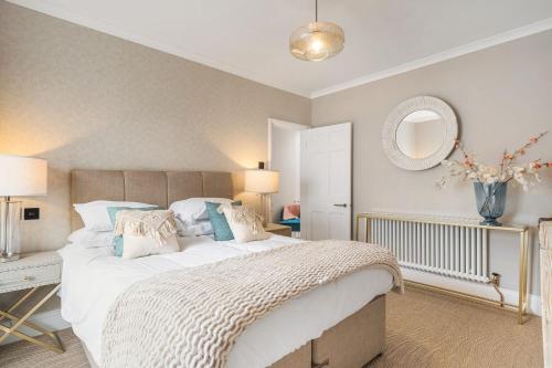 a bedroom with a large bed and a mirror at Tregurno in St Ives