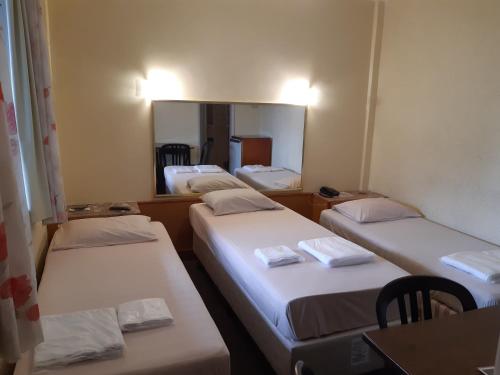 a group of three beds in a room with a mirror at Hotel Paraguai (Adult Only) in Rio de Janeiro