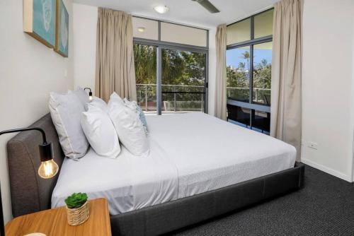 a bedroom with a large bed and a window at Pool View City Centre Apartment 202 in Cairns