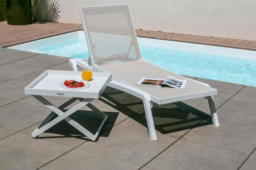a white chair and a table and a bowl of fruit at Intelier Rosa in Castellón de la Plana