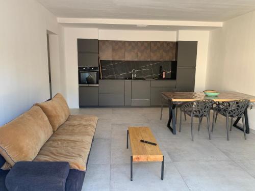 a living room with a couch and a table at Maison neuve 2 min mer in Corbara