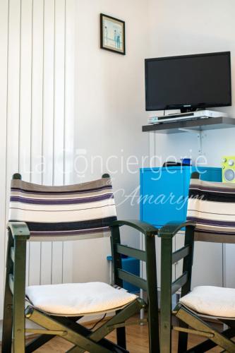 deux chaises et un bureau avec une télévision dans une pièce dans l'établissement AL36 - Appartement vue mer exceptionnelle, à Ault