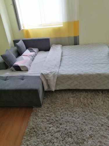 a large bed in a room with a window at NIKAS Apartman in Donji Milanovac