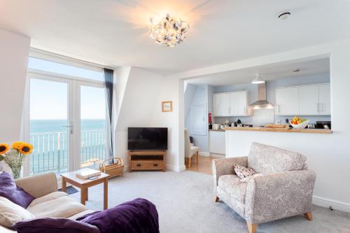 a living room with a couch and a kitchen at No 5 Compass - Ilfracombe in Ilfracombe