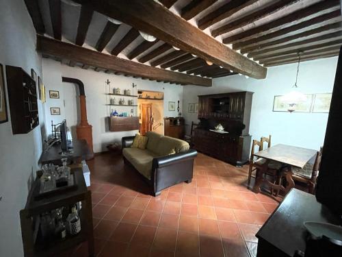 a living room with a couch and a piano at Borgo la Ruga - Tuscany Home in Chianni