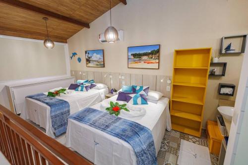 a room with two beds and a sink in it at Flat Solar Água 127 - Family & Friends in Pipa