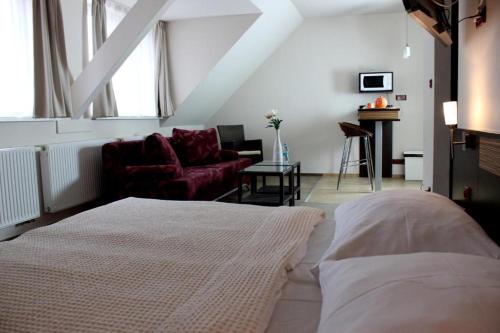 - une chambre avec un lit et un salon dans l'établissement AdamEva Resort, à Piešťany
