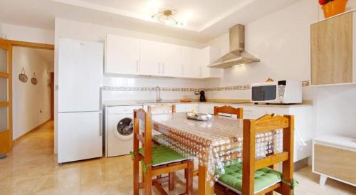 a kitchen with a table and chairs in a kitchen at APARTMENT ORANGE FUERTEVENTURA in Puerto del Rosario