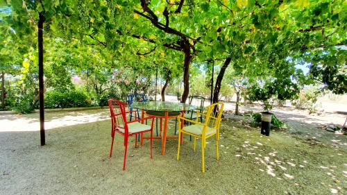 a table and four chairs sitting under a tree at Finca La Calancha in Cuerva