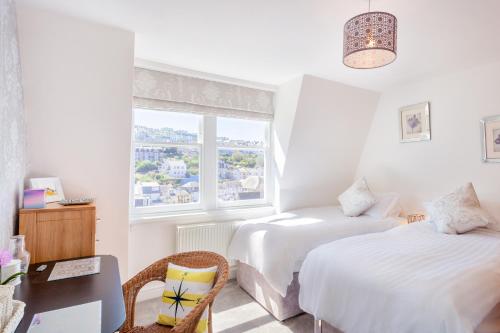 a hotel room with two beds and a window at No 5 Compass - Ilfracombe in Ilfracombe