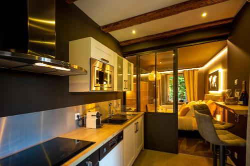 a kitchen with a sink and a room with a bed at La Suite - Spa & Sauna in Kaysersberg