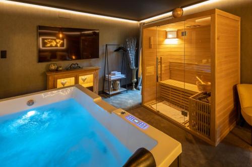 凱澤貝爾的住宿－La Suite - Spa & Sauna，带淋浴的浴室内的大型浴缸