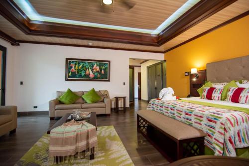 a hotel room with two beds and a couch at Hotel Arenal Springs Resort & Spa in Fortuna