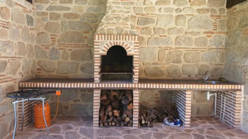 a large brick oven with a pile of logs at Finca La Calancha in Cuerva