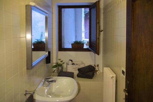 baño con lavabo y 2 ventanas en Accogliente locale con terrazzo in centro storico, en Vittorio Veneto
