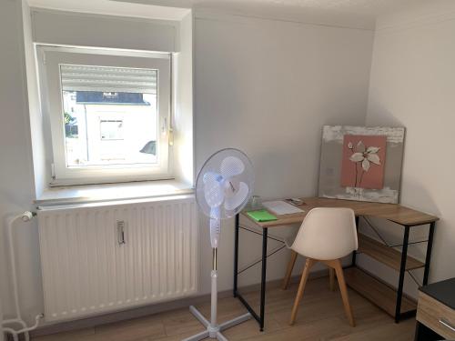 a room with a desk and a fan and a window at Nice rooms in Beggen house - In Luxembourg city in Luxembourg