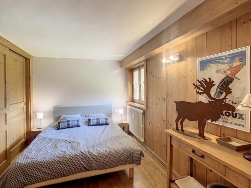 une chambre avec un lit et un mur en bois dans l'établissement 3 pièces, piscine intérieure, parking, proche centre à Combloux - FR-1-560-27, à Combloux