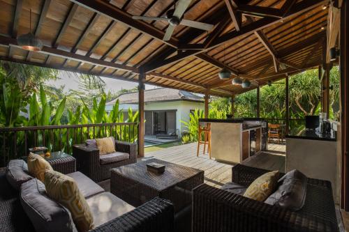 an outdoor patio with couches and a fireplace at Villa Markisa Echo Beach in Canggu