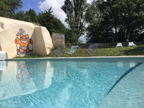 a swimming pool with chairs and a painting on the wall at Les pieds dans l'eau - Gîte de L'olivier - Plage privée in Blacons