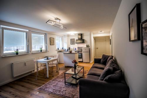 uma sala de estar com um sofá e uma mesa em Exklusive Neubau Wohnung im Luftkurort Buchholz em Buchholz in der Nordheide