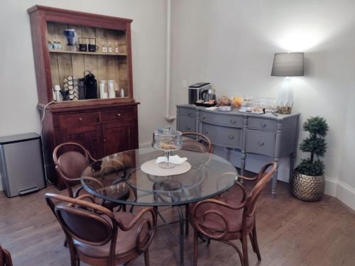 une salle à manger avec une table et des chaises en verre dans l'établissement Augusta Guest House, à Augusta