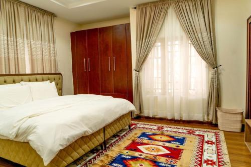a bedroom with a bed and a large window at Integral Consults Apartment in Abuja