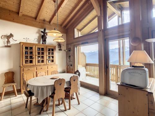 une salle à manger avec une table et une grande fenêtre dans l'établissement Duplex cosy à deux pas des pistes avec parking à Combloux - FR-1-560-80, à Combloux