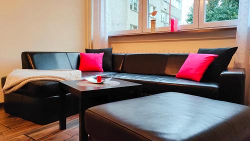 a living room with a leather couch and a table at Wisienka in Duszniki Zdrój