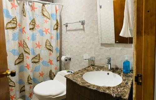y baño con lavabo, aseo y cortina de ducha. en Casa Arena San Andres, en San Andrés