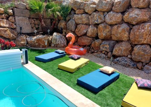 a toy swan sitting on the grass next to a pool at La Belle Vie en Alaric in Douzens