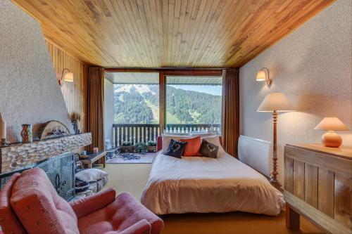 a bedroom with a bed and a large window at Les Marmottes du Morzena in Morzine