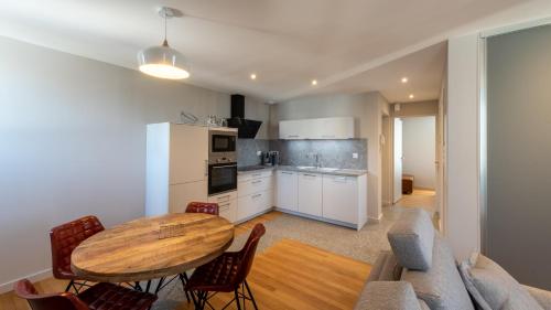 une cuisine et un salon avec une table et un canapé dans l'établissement L'Aubrac, T2 classé meublé de tourisme, à Rodez