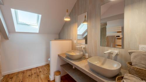 une salle de bains avec deux lavabos sur un comptoir dans l'établissement Le Grenier Cosy, T2 classé meublé de tourisme, à Rodez