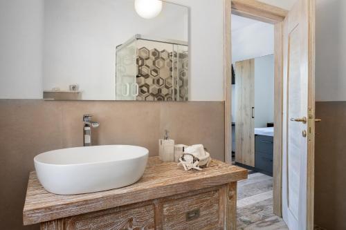 een badkamer met een grote witte wastafel op een houten aanrecht bij Il Mirto in Baja Sardinia