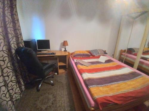 1 dormitorio con escritorio, ordenador y cama en Apartmani Safo 2, en Visoko