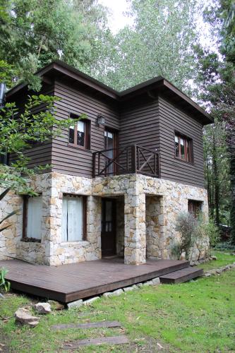 uma casa com um deque de madeira em frente em Cabañas Las Olivas em Mar del Plata