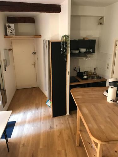 a kitchen with a wooden table and a kitchen with a door at Studio hyper centre Toulouse in Toulouse