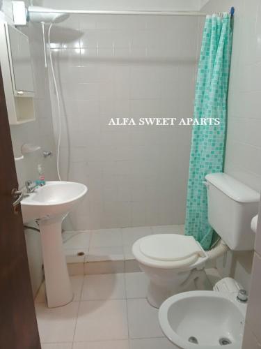 a bathroom with a white toilet and a sink at ALFA SWEET APARTS in Formosa