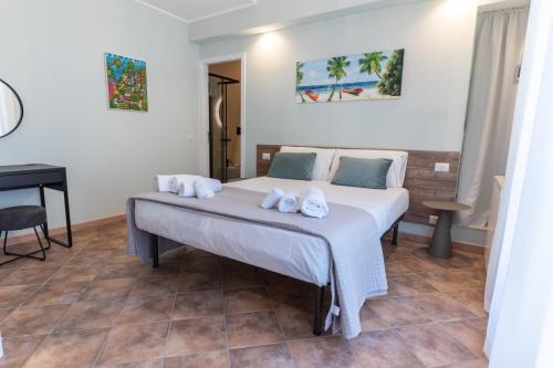 een slaapkamer met een bed met handdoeken erop bij Teo House Beach in Taormina