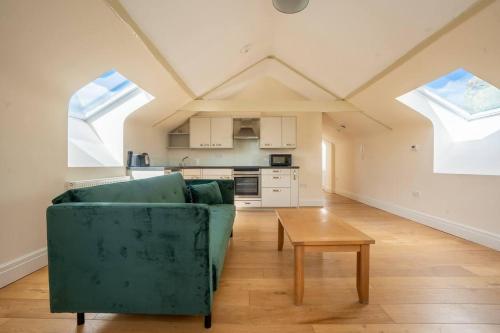 uma sala de estar com um sofá verde e uma mesa em Charming 1-Bed loft in Caerleon em Newport