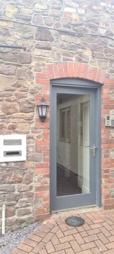eine Backsteinwand mit einer Tür und einem Fenster in der Unterkunft Charming 1-Bed loft in Caerleon in Newport