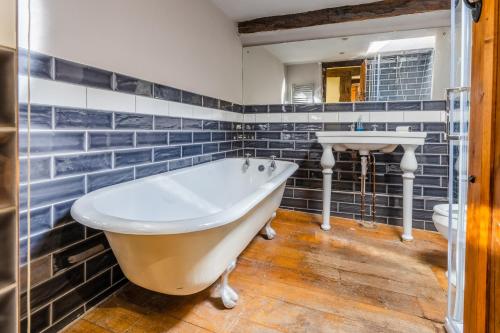een badkamer met een groot bad en een wastafel bij Remarkable 4-Bed Cottage in Cearleon in Newport