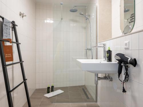 een badkamer met een wastafel en een douche bij limehome Eindhoven Gashouder in Eindhoven