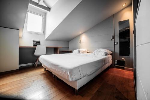une chambre avec un grand lit blanc et une fenêtre dans l'établissement Wonder Duplex 7, à Toulouse
