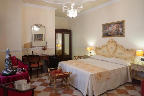 a bedroom with a bed and a table and a mirror at Hotel Trinacria in Palermo