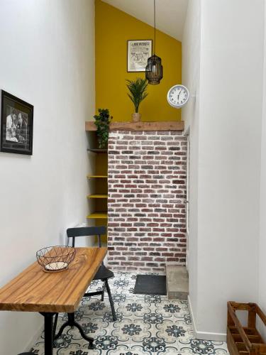 Cette chambre dispose d'une table et d'une cheminée en briques. dans l'établissement Marée Ault - maison moderne rénovée échappée mer, à Ault
